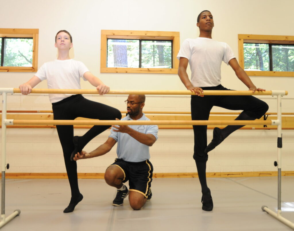 Ballet dancers practicing with teacher in ballet class